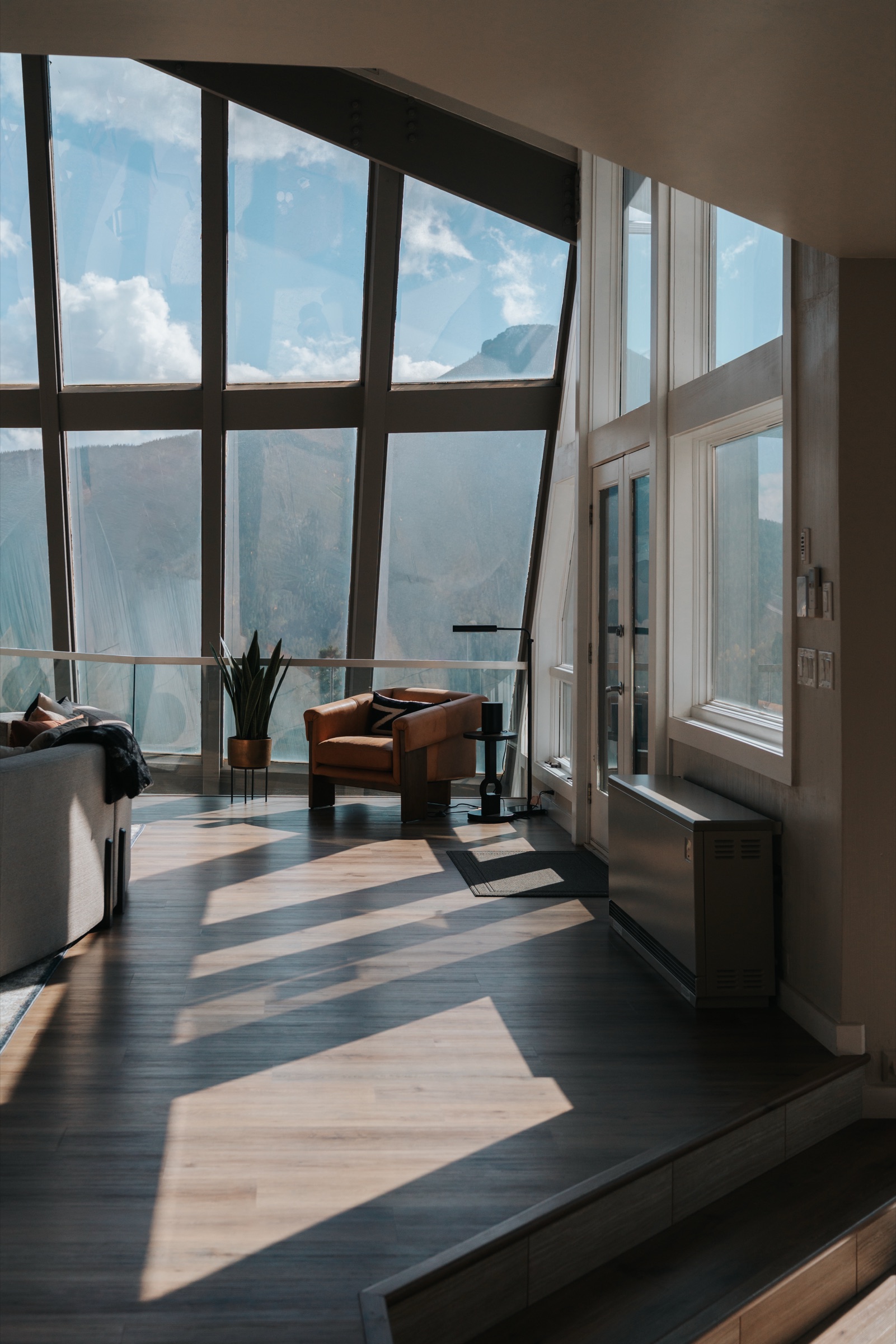 Vaulted living room with shadow rays from the angled glass wall