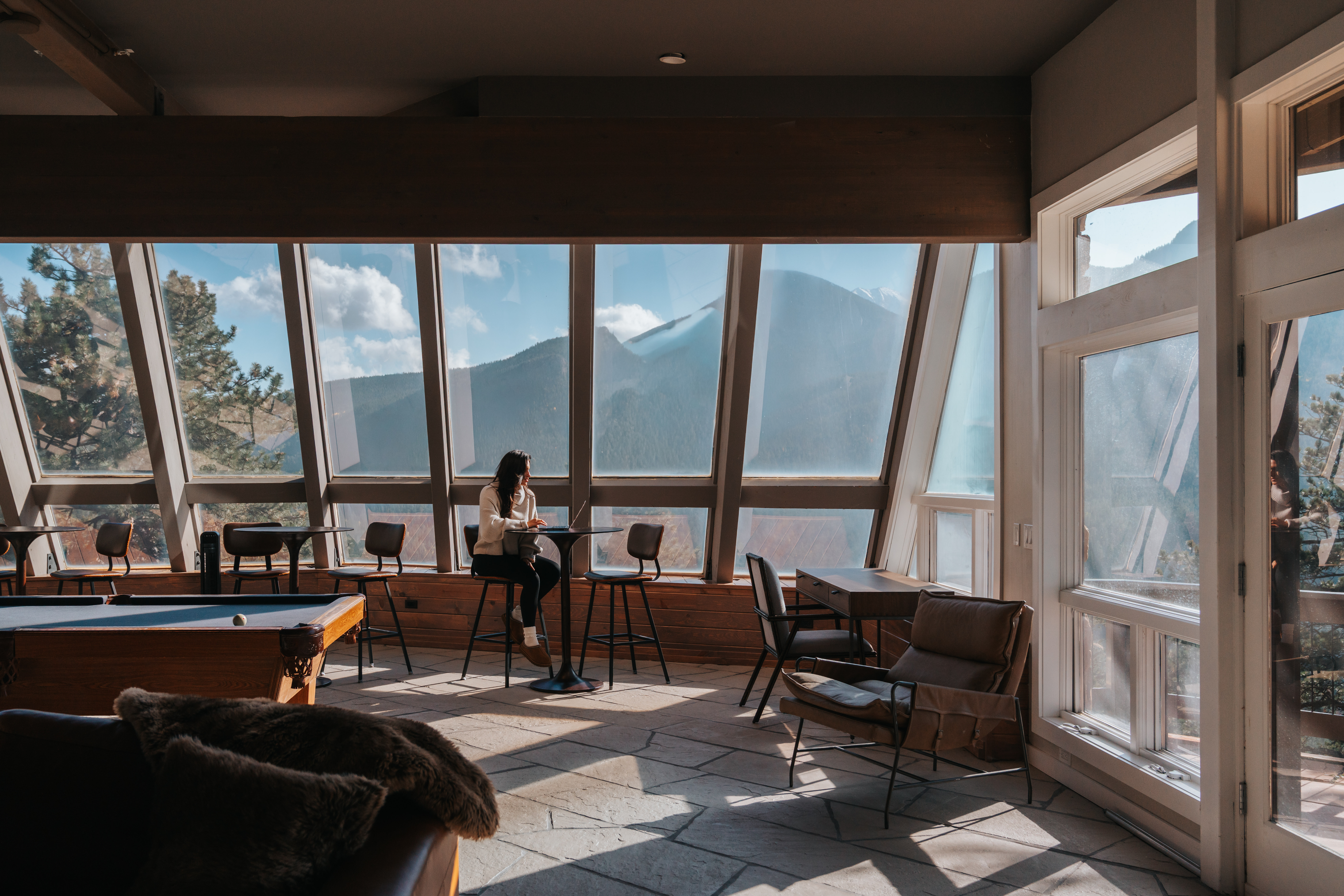 Coffee, mountains, and morning light in the lower living room at Casa de Cristal