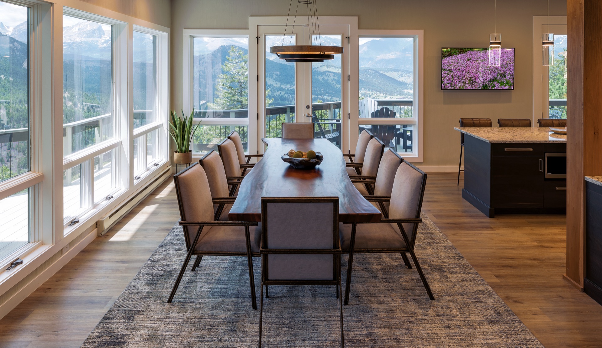 A chef's dream kitchen flows into a dining space with stunning mountain views