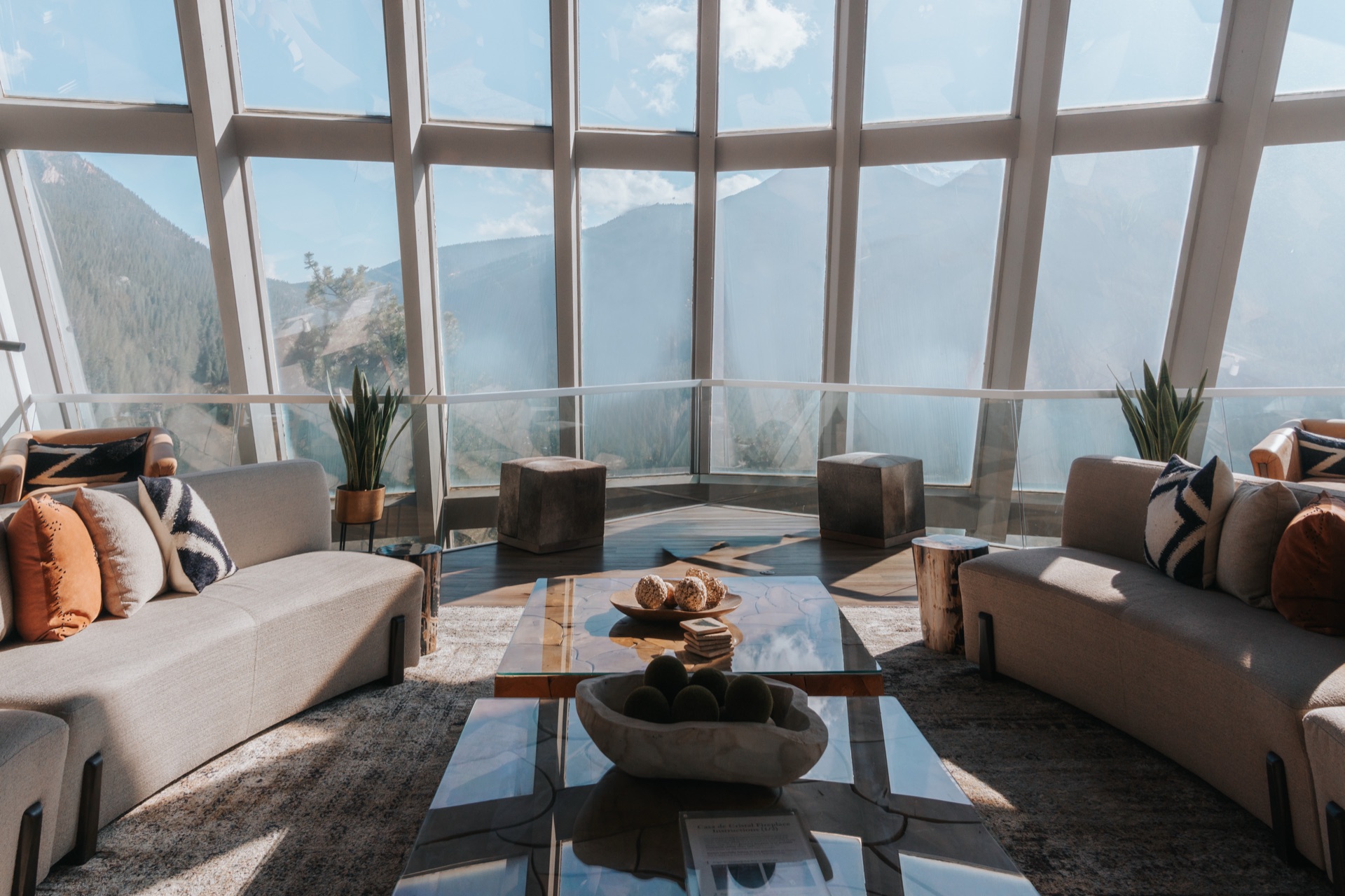 Floor-to-ceiling glass walls revealing panoramic mountain views from every angle