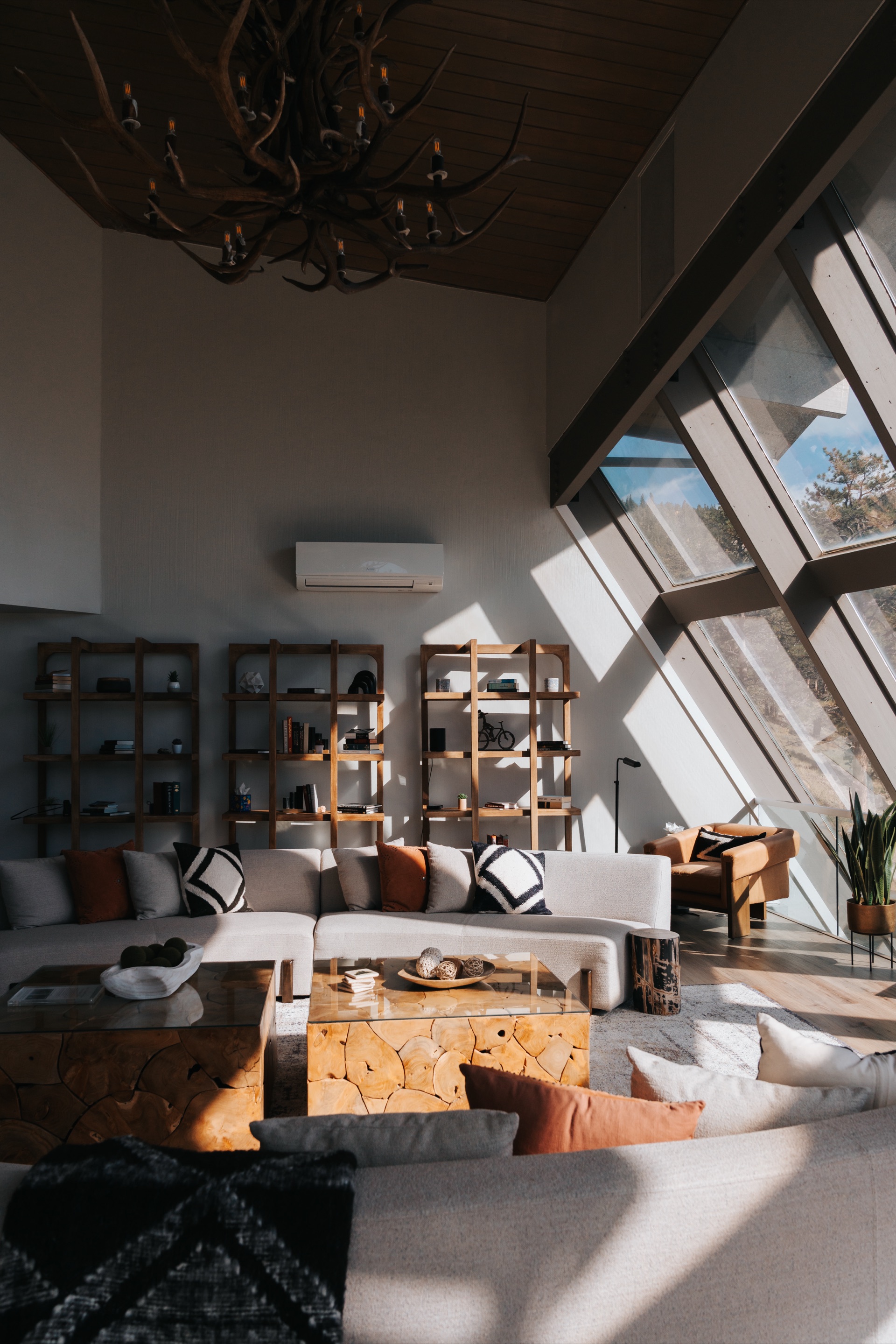 Casa de Cristal upstairs living room with floor-to-ceiling glass walls overlooking the Rocky Mountains