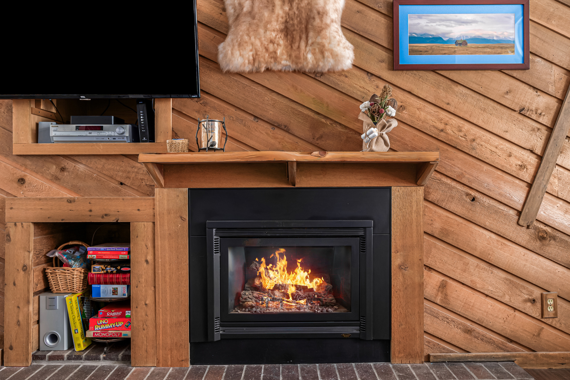 Fireplace detail with board games and cozy decor
