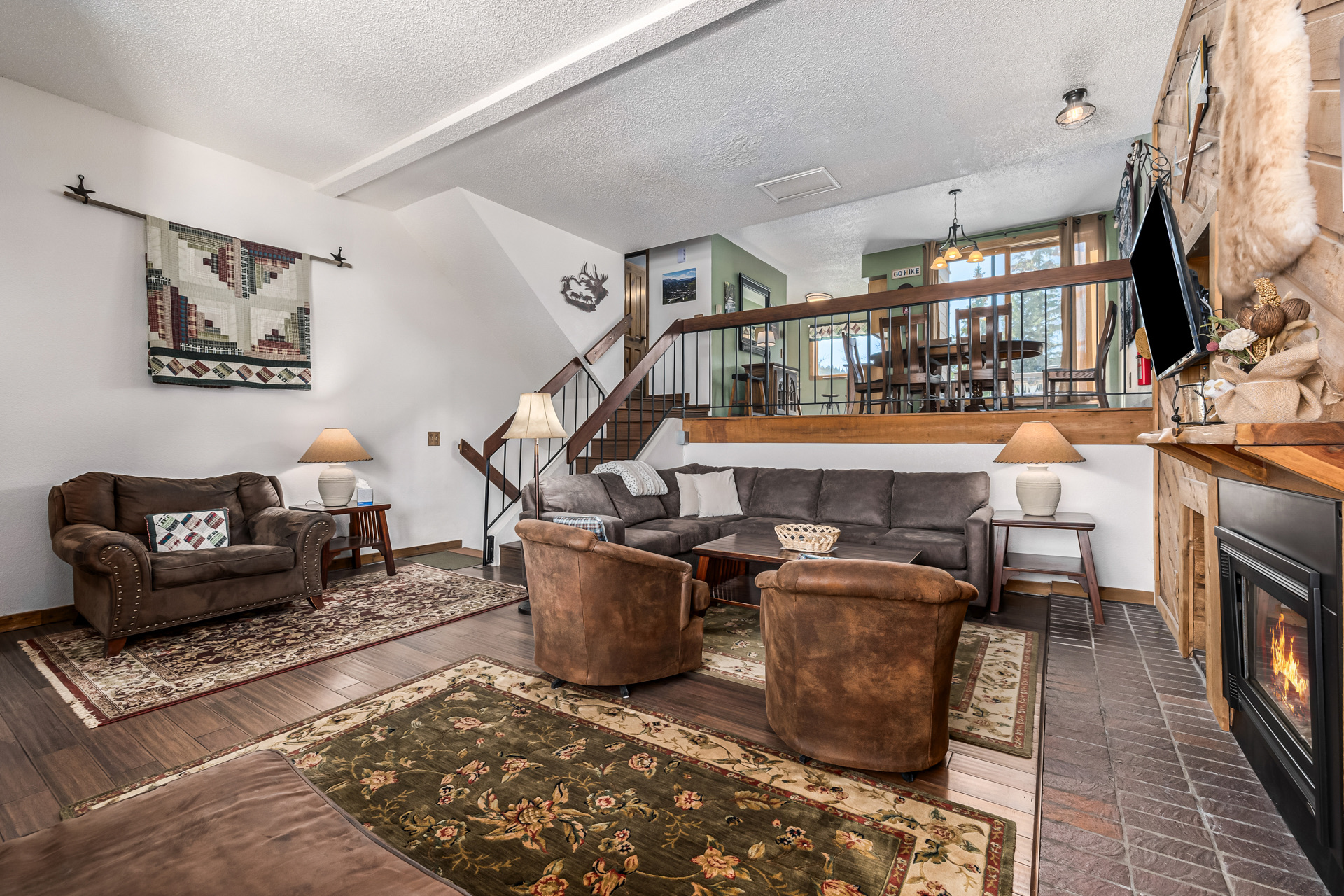 View from stairway into living room with quilt on wall