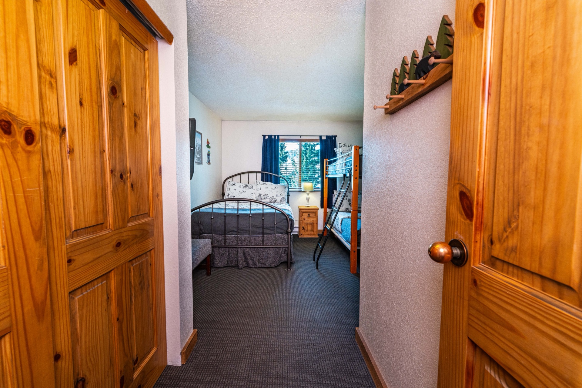 Second bedroom with blue bedding and pine closets