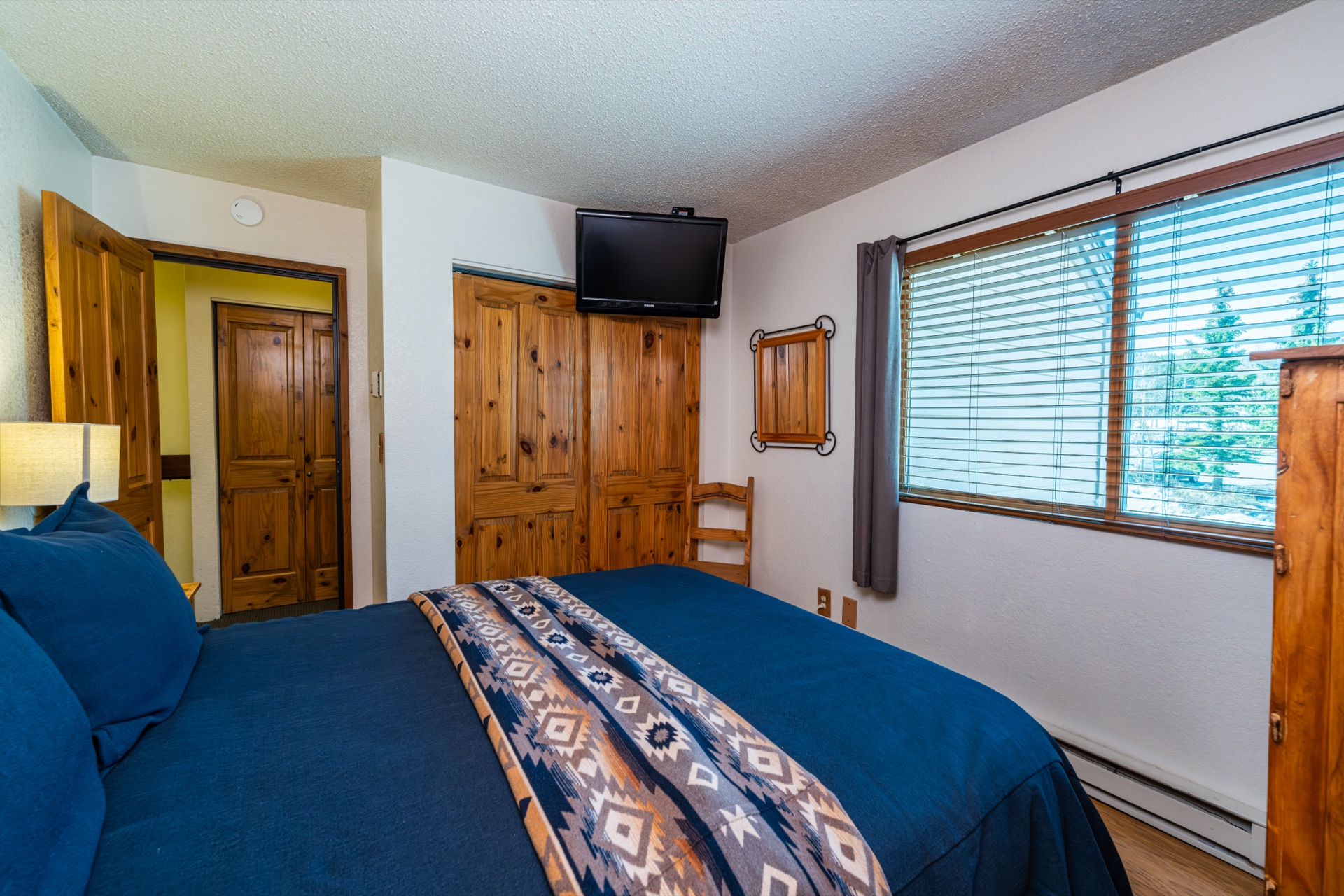 Second bedroom: queen bed, luxury linens, TV; shares bath with third room.