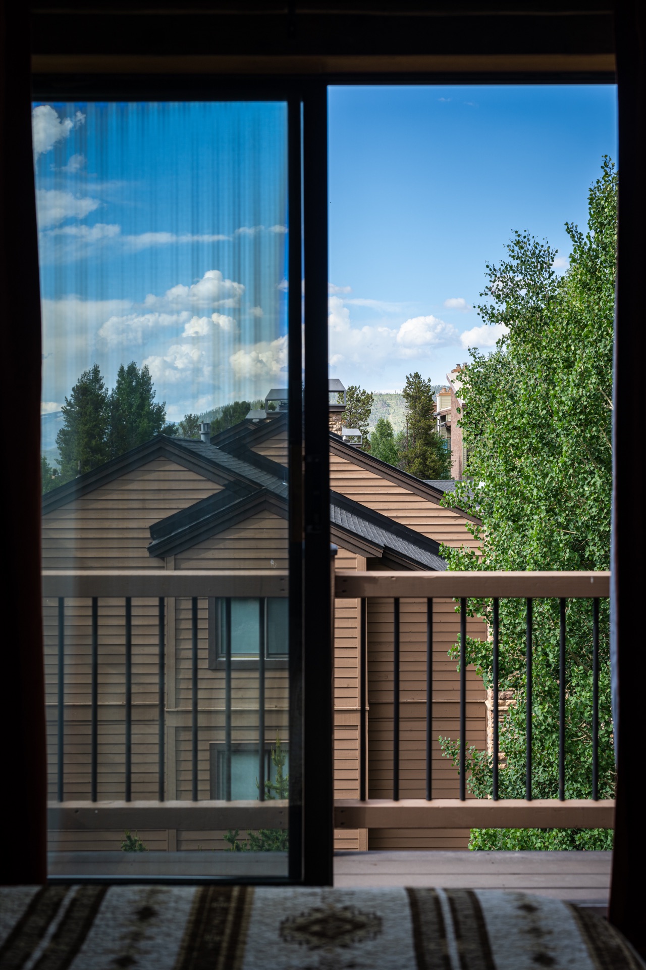 View through door to deck with mountain scenery
