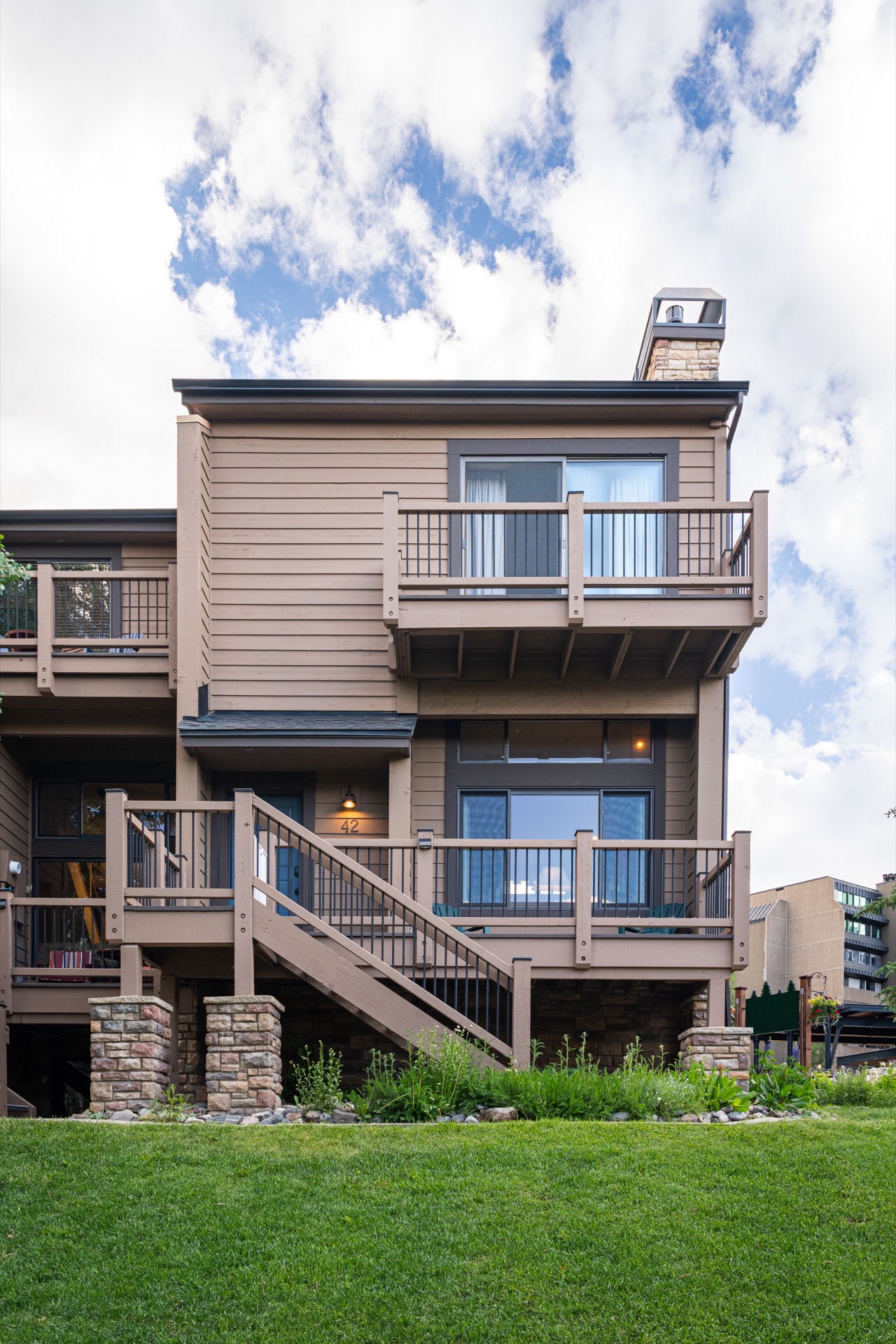 Townhouse façade with two-level deck and Adirondack seating