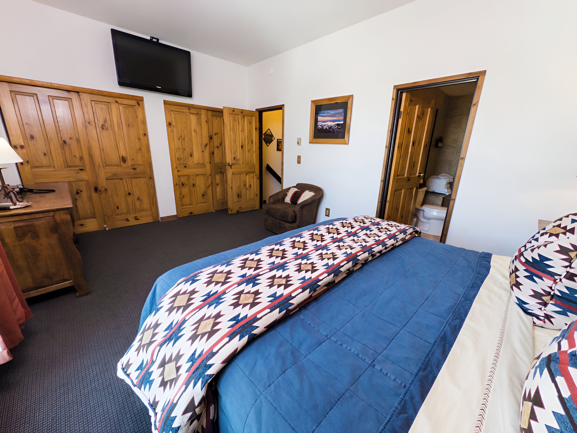 Master bedroom with king bed, wooden headboard, and Southwestern bedding