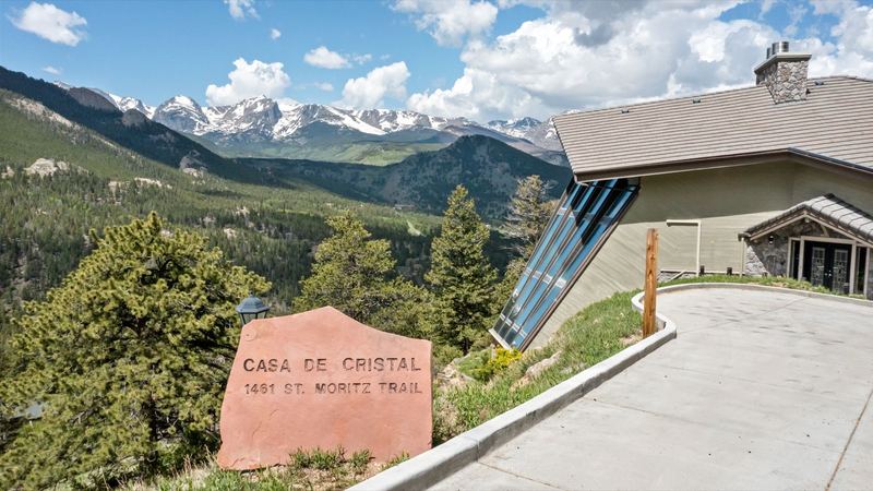 Casa de Cristal entrance with stone sign and Rocky Mountains
