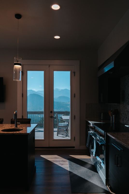 Gourmet kitchen looking through French doors to deck and mountain panorama